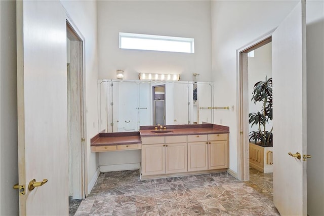 3128 Palm Vista Dr, Metairie, LA 70003 - bathroom featuring vanity, marble look tiles, and a towering ceiling