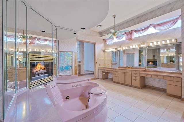 3128 Palm Vista Dr, Metairie, LA 70003 - bathroom with a fireplace, a tub with jets, vanity, tile patterned flooring, and a ceiling fan