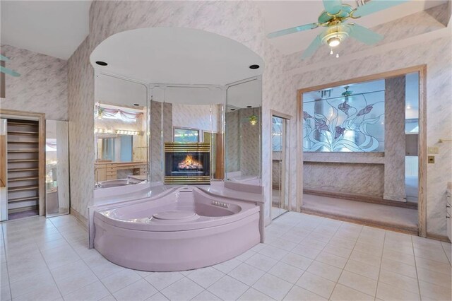 3128 Palm Vista Dr, Metairie, LA 70003 - bathroom with tile patterned floors, wallpapered walls, a bath, a fireplace, and a ceiling fan