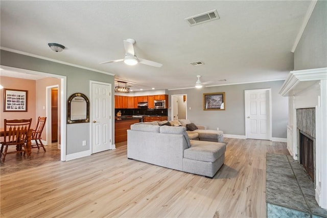 4808 Fairfield St, Metairie, LA 70006 - living area featuring ceiling fan, light wood-style flooring, ornamental molding, and a fireplace