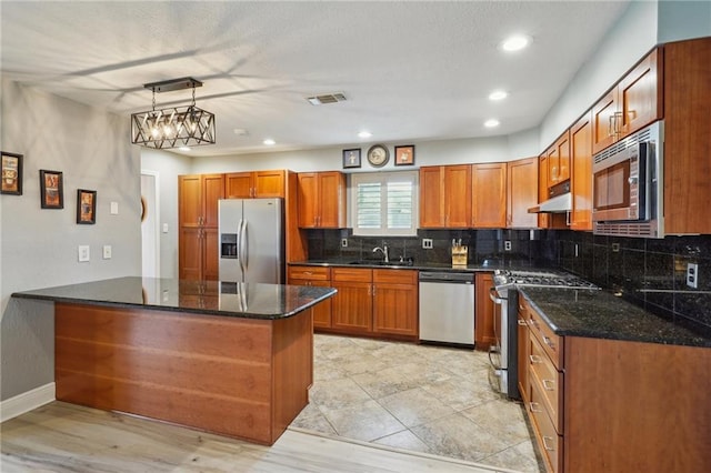 4808 Fairfield St, Metairie, LA 70006 - kitchen with appliances with stainless steel finishes, under cabinet range hood, backsplash, recessed lighting, and dark stone countertops