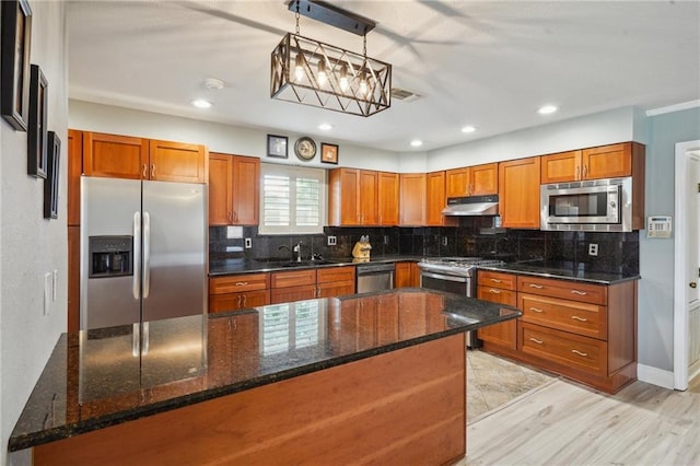 4808 Fairfield St, Metairie, LA 70006 - kitchen featuring stainless steel appliances, under cabinet range hood, brown cabinets, light wood-type flooring, and recessed lighting