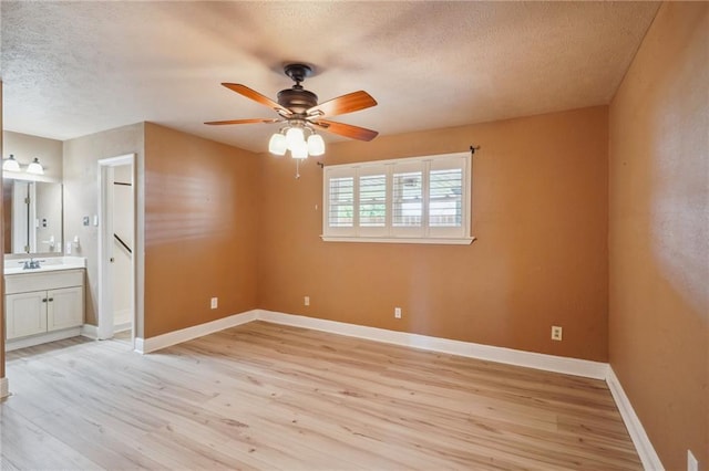 4808 Fairfield St, Metairie, LA 70006 - unfurnished bedroom featuring a textured ceiling, light wood-style flooring, ensuite bathroom, and a ceiling fan