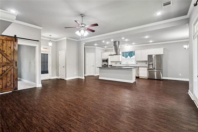 44128 Halter Ln, Hammond, LA 70403 - unfurnished living room with a barn door, dark wood-type flooring, a ceiling fan, recessed lighting, and ornamental molding