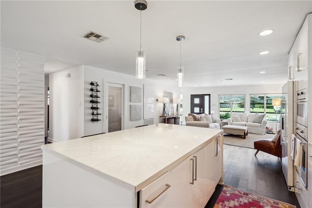 525 Bellview St, River Ridge, LA 70123 - kitchen with dark wood-style floors, a center island, white cabinetry, light countertops, and recessed lighting