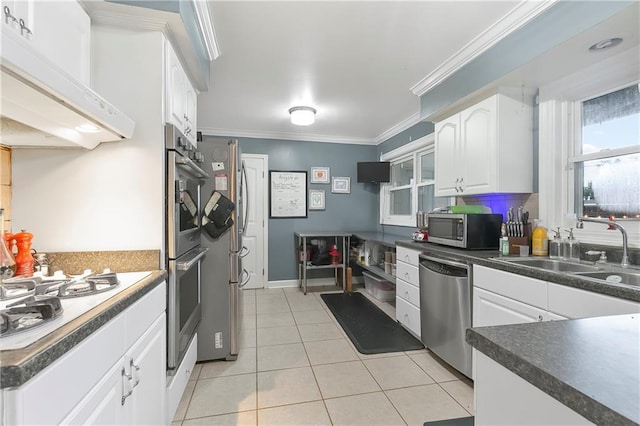 5921 Rickey St, Metairie, LA 70003 - kitchen featuring stainless steel appliances, white cabinetry, light tile patterned floors, dark countertops, and ornamental molding