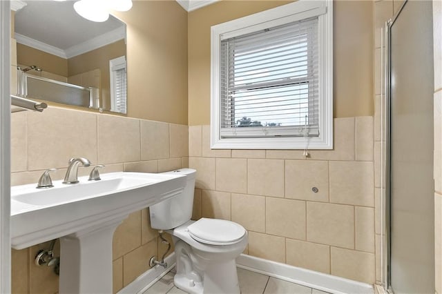 5921 Rickey St, Metairie, LA 70003 - bathroom featuring tile walls, ornamental molding, an enclosed shower, tile patterned floors, and a wainscoted wall
