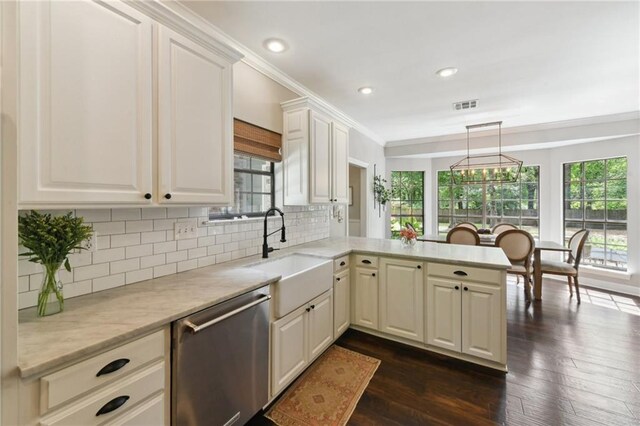 103 Century Oaks Ln, Mandeville, LA 70471 - kitchen featuring stainless steel dishwasher, a peninsula, dark wood-type flooring, tasteful backsplash, and crown molding