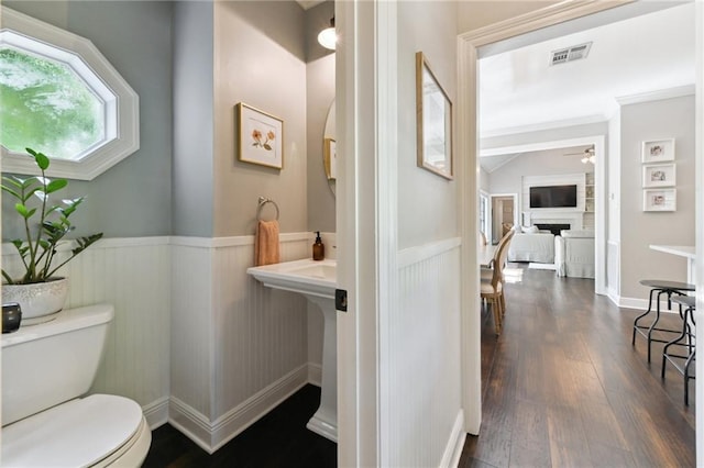 103 Century Oaks Ln, Mandeville, LA 70471 - half bath featuring a fireplace, wainscoting, ceiling fan, and wood finished floors