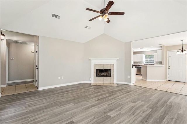 3298 Rama St, Slidell, LA 70458 - unfurnished living room featuring light wood-style flooring, ceiling fan, lofted ceiling, a fireplace, and a chandelier