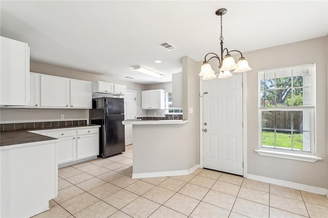 3298 Rama St, Slidell, LA 70458 - kitchen featuring freestanding refrigerator, white cabinets, a chandelier, light tile patterned floors, and plenty of natural light
