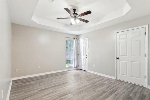 3298 Rama St, Slidell, LA 70458 - empty room with a tray ceiling, a ceiling fan, and light wood-type flooring
