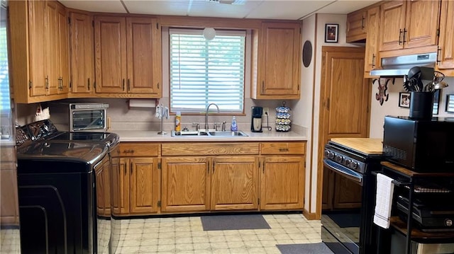 217 Evangeline Rd, Montz, LA 70068 - kitchen with independent washer and dryer, under cabinet range hood, light floors, black appliances, and light countertops