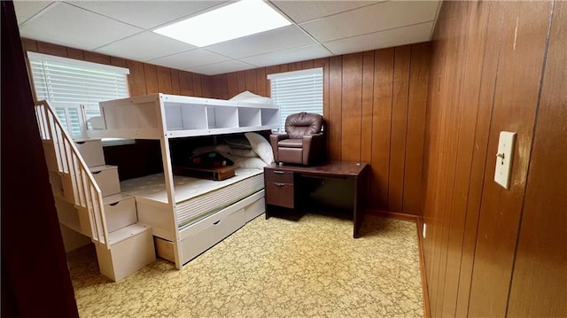 217 Evangeline Rd, Montz, LA 70068 - bedroom with wooden walls, a drop ceiling, light flooring, and multiple windows