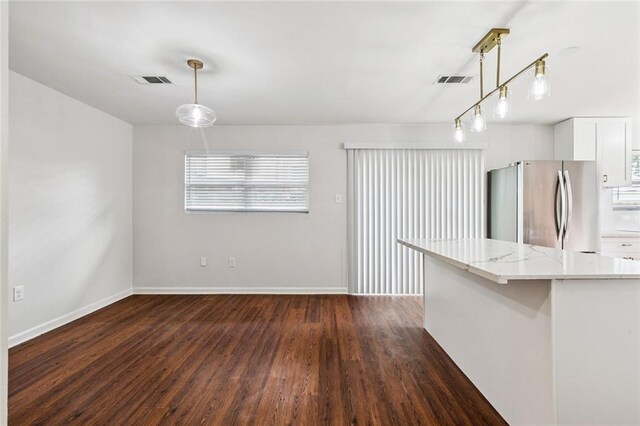 802 Claiborne Dr, Jefferson, LA 70121 - kitchen featuring freestanding refrigerator, dark wood-style floors, light stone counters, and decorative light fixtures