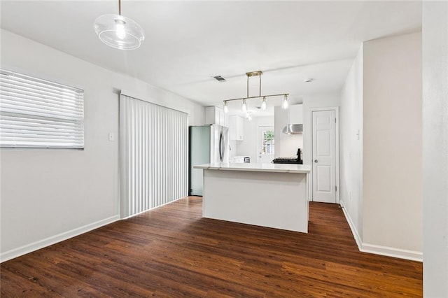 802 Claiborne Dr, Jefferson, LA 70121 - kitchen featuring white cabinets, dark wood-style flooring, light countertops, decorative light fixtures, and a kitchen island