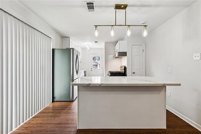 802 Claiborne Dr, Jefferson, LA 70121 - kitchen featuring freestanding refrigerator, range with gas stovetop, under cabinet range hood, white cabinets, and dark wood-style floors