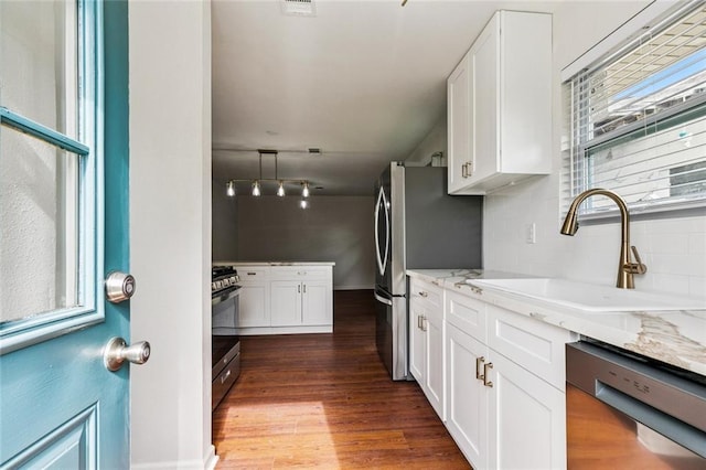 802 Claiborne Dr, Jefferson, LA 70121 - kitchen featuring appliances with stainless steel finishes, white cabinets, dark wood-type flooring, and light stone counters