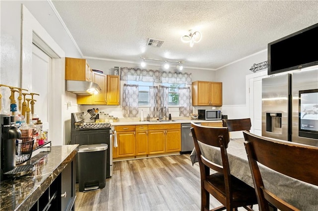 413 Fir St, La Place, LA 70068 - kitchen featuring stainless steel appliances, under cabinet range hood, light wood finished floors, crown molding, and a textured ceiling