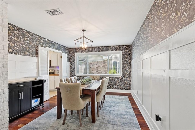 400 W Lake Catahoula Ct, Slidell, LA 70461 - dining area with wallpapered walls, a chandelier, dark wood-style floors, and a wainscoted wall