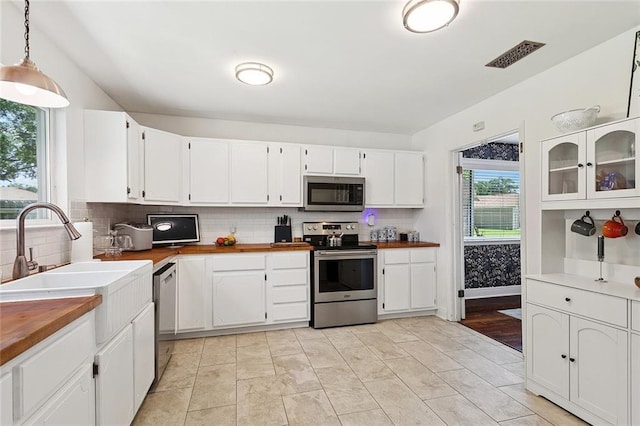 400 W Lake Catahoula Ct, Slidell, LA 70461 - kitchen featuring appliances with stainless steel finishes, butcher block counters, tasteful backsplash, white cabinetry, and decorative light fixtures