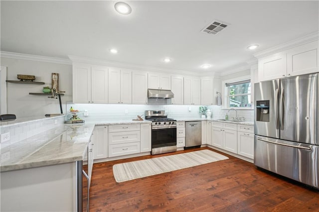 1213 Focis St, Metairie, LA 70005 - kitchen with appliances with stainless steel finishes, under cabinet range hood, ornamental molding, tasteful backsplash, and white cabinetry
