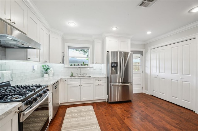 1213 Focis St, Metairie, LA 70005 - kitchen with stainless steel appliances, under cabinet range hood, dark wood-type flooring, white cabinetry, and light stone counters