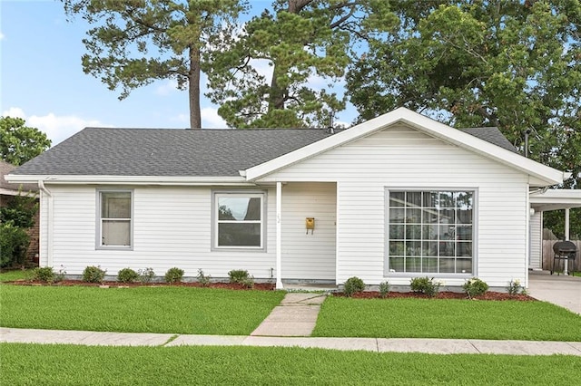 42 Tulip Dr, Gretna, LA 70053 - ranch-style home with a front yard, roof with shingles, an attached carport, and driveway