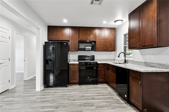 42 Tulip Dr, Gretna, LA 70053 - kitchen with black appliances, light wood-type flooring, recessed lighting, light stone countertops, and dark brown cabinets