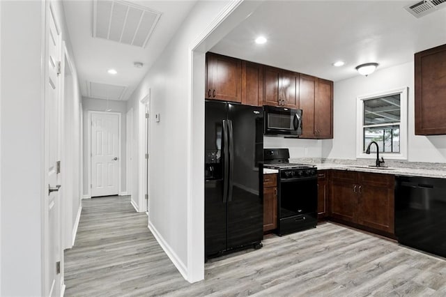 42 Tulip Dr, Gretna, LA 70053 - kitchen featuring black appliances, light wood-style floors, dark brown cabinetry, recessed lighting, and light stone countertops