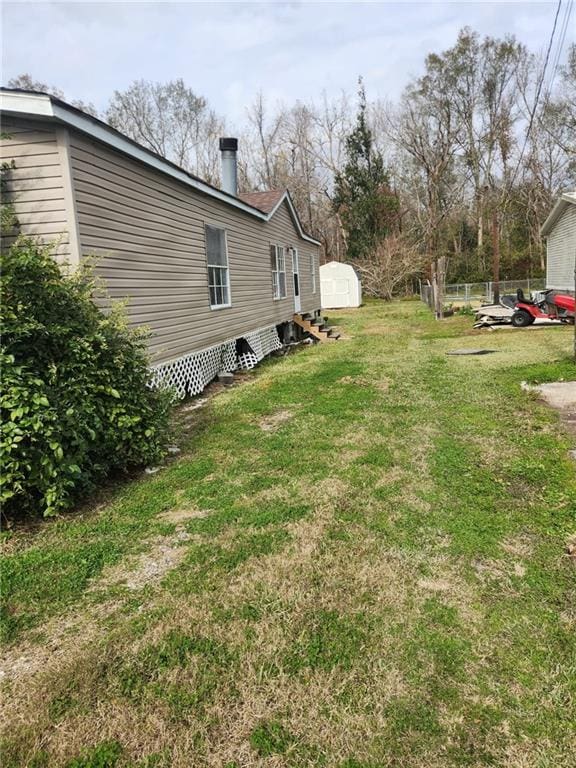 116 Cedar Dr, Belle Chasse, LA 70037 - view of grassy yard featuring a storage shed and entry steps