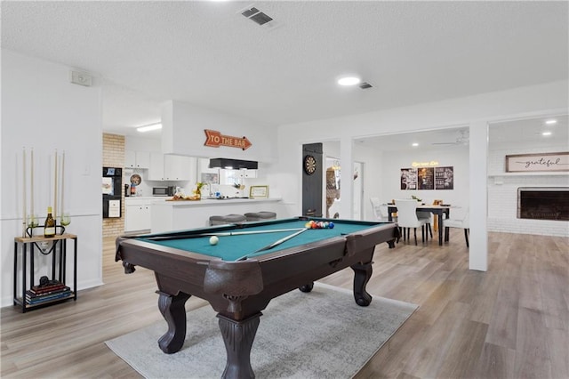 109 Sherry Dr, Hammond, LA 70401 - recreation room with light wood-style flooring, billiards, a textured ceiling, and a fireplace