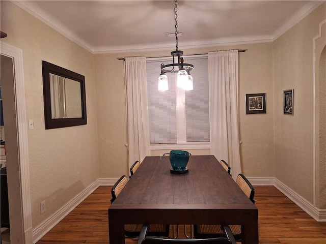 4712 Lafaye St, New Orleans, LA 70122 - dining space with dark wood finished floors, ornamental molding, a chandelier, and arched walkways