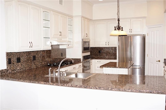 3739 N Hullen St, Metairie, LA 70002 - kitchen with stainless steel appliances, ornamental molding, a peninsula, dark stone counters, and under cabinet range hood