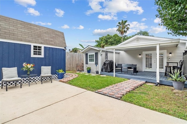 1200 Waltham St, Metairie, LA 70001 - rear view of property featuring a wooden deck, a patio, an outdoor structure, and french doors