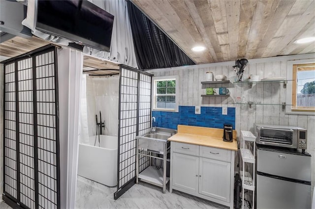 1200 Waltham St, Metairie, LA 70001 - kitchen featuring freestanding refrigerator, wooden ceiling, open shelves, light countertops, and white cabinets