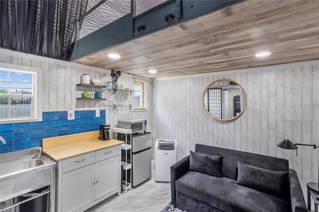 1200 Waltham St, Metairie, LA 70001 - living room with light marble finish flooring, wood walls, and wooden ceiling