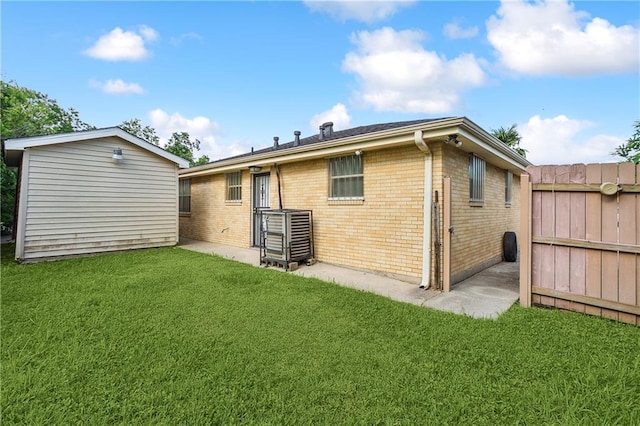 4925 Rhodes Dr, New Orleans, LA 70126 - back of property with brick siding, a lawn, and an outbuilding