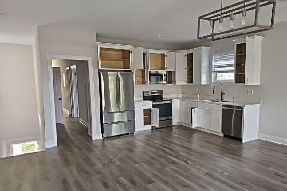 2678 Myrtle St, New Orleans, LA 70122 - kitchen with appliances with stainless steel finishes, light countertops, white cabinets, and dark wood-style floors