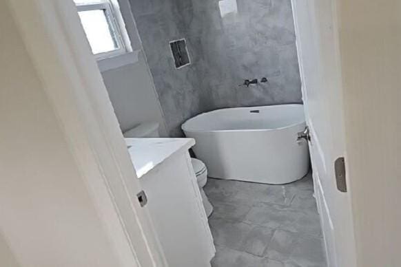 2678 Myrtle St, New Orleans, LA 70122 - full bathroom featuring a freestanding bath, vanity, and concrete flooring