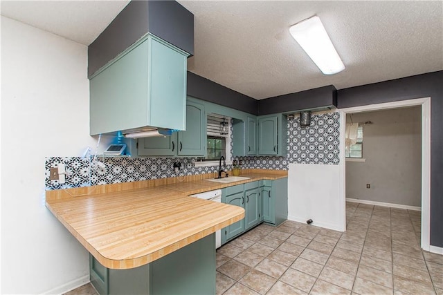 2129 Hamilton St, Franklinton, LA 70438 - kitchen with green cabinets, backsplash, a peninsula, a textured ceiling, and a breakfast bar