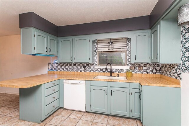 2129 Hamilton St, Franklinton, LA 70438 - kitchen with white dishwasher, a peninsula, light countertops, backsplash, and light tile patterned flooring