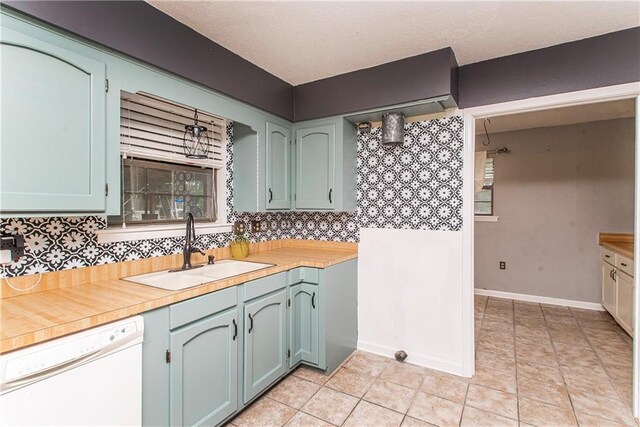 2129 Hamilton St, Franklinton, LA 70438 - kitchen featuring white dishwasher, decorative backsplash, light countertops, and light tile patterned flooring