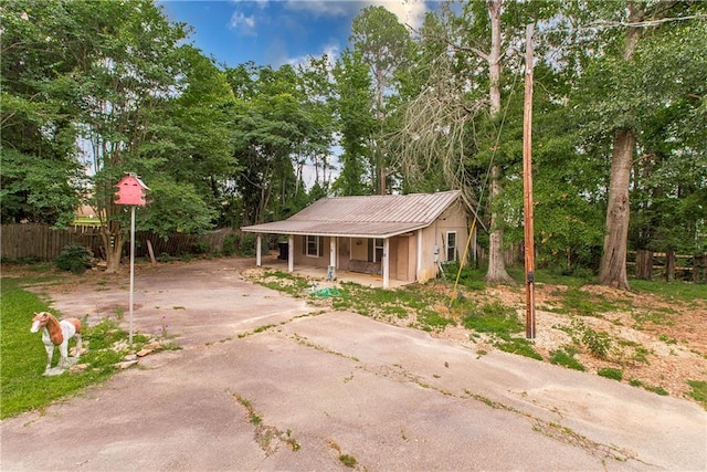 2129 Hamilton St, Franklinton, LA 70438 - view of front of property featuring covered porch, driveway, a metal roof, and view of scattered trees