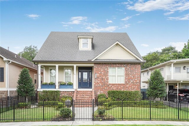 6938 Milne Blvd, New Orleans, LA 70124 - view of front of house with a porch, brick siding, a fenced front yard, and a shingled roof