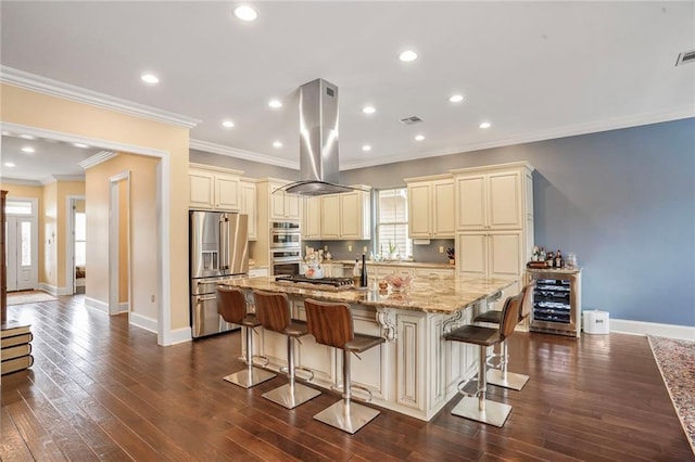 6938 Milne Blvd, New Orleans, LA 70124 - kitchen featuring cream cabinets, island exhaust hood, stainless steel appliances, beverage cooler, and recessed lighting