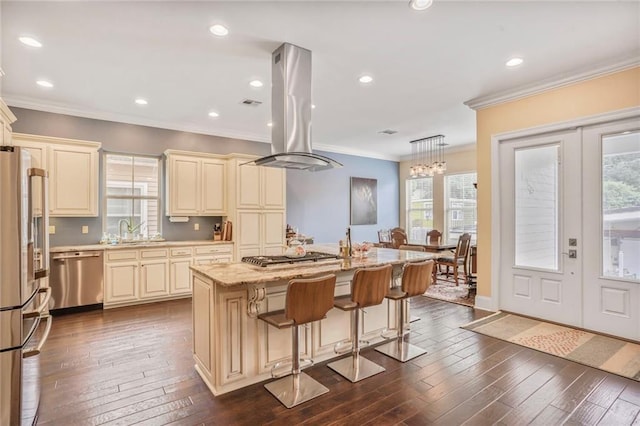 6938 Milne Blvd, New Orleans, LA 70124 - kitchen with cream cabinetry, appliances with stainless steel finishes, island range hood, crown molding, and dark wood-type flooring