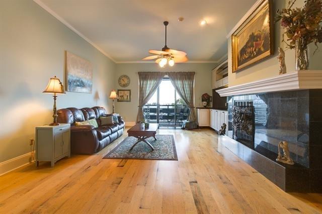 7300 Lakeshore Dr Unit 6, New Orleans, LA 70124 - living room with ornamental molding, ceiling fan, wood finished floors, and a fireplace