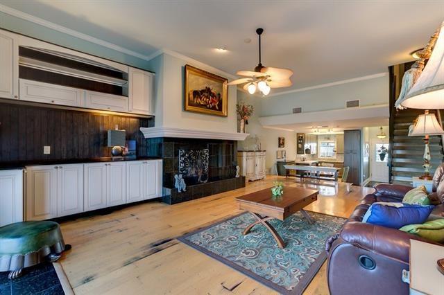7300 Lakeshore Dr Unit 6, New Orleans, LA 70124 - living area featuring a ceiling fan, a tile fireplace, crown molding, and wood finished floors