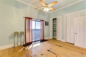 7300 Lakeshore Dr Unit 6, New Orleans, LA 70124 - unfurnished bedroom featuring wood finished floors, ornamental molding, a ceiling fan, and multiple closets